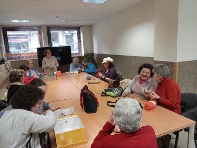 Voluntarias de Asociación ZOES Salamanca, ayudan a tejer a socias de Supo Salamanca-Avila-Zamora en el taller "Punto de encuentro"